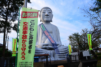 交通事故防止のタスキを掛けた布袋の大仏の写真