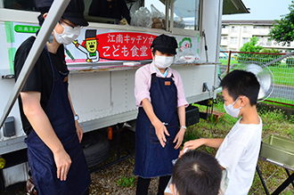 カレーピラフを受け取る子どもの写真