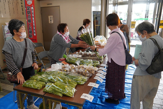 消費生活展（朝市の野菜販売のようす）の写真