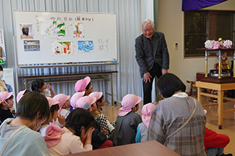 はなまつりの説明を聞いている年長児たち